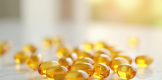 Capsules de vitamine D3 dorées sur marbre blanc