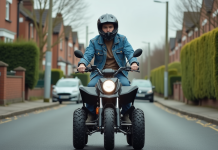 Jeune homme en denim sur quad en quartier calme