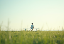 Personne assise paisiblement sur un banc blanc dans un champ