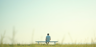 Personne assise paisiblement sur un banc blanc dans un champ